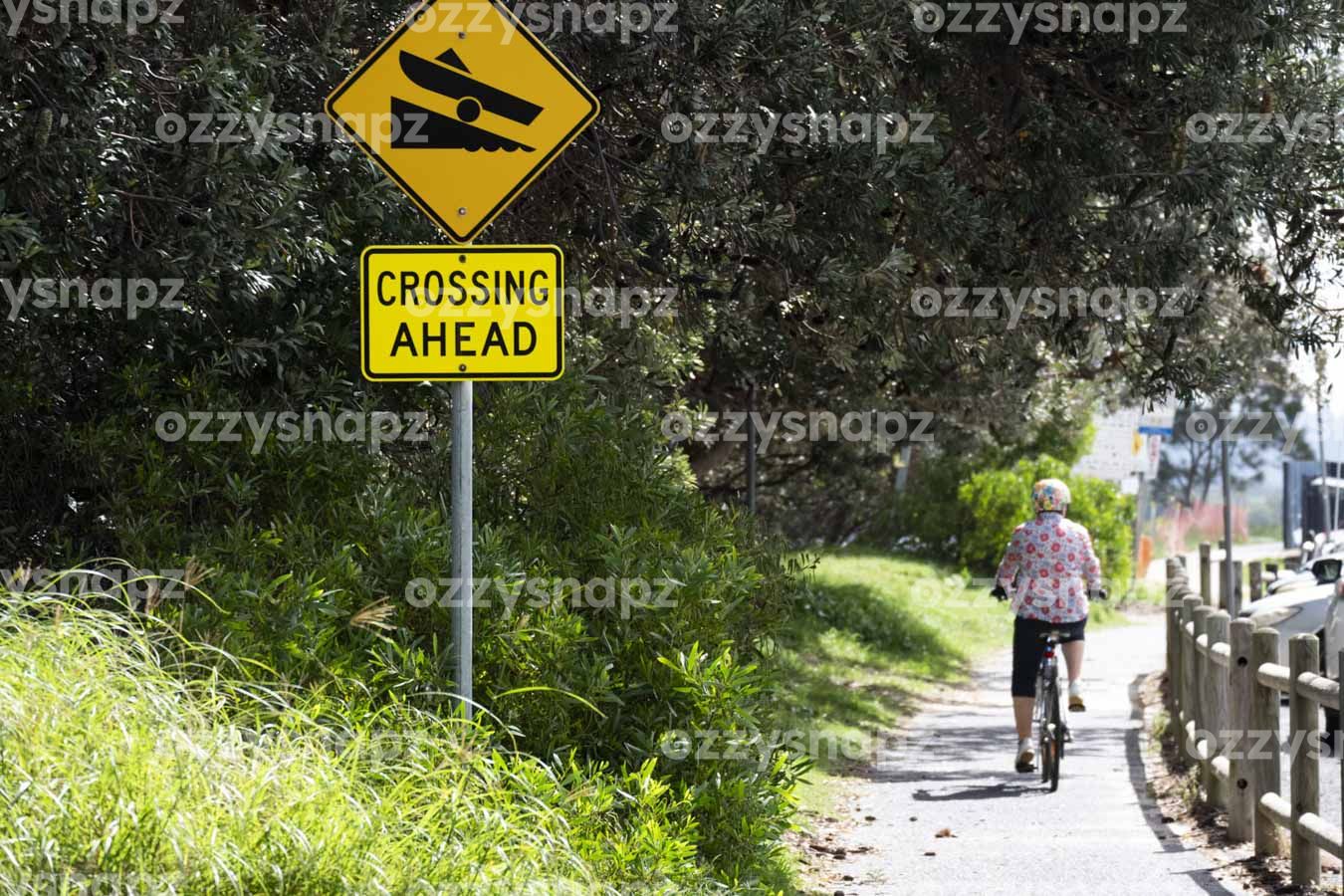 Ballina's Yacht Club Boat Ramp sign at the Kerry Saxby walkway - ID: 221167 A person riding a bike in The Kerry Saxby walkway next to the Yacht Club Boat Ramp sign next to the Richmond River in Central Ballina, Northern Rivers Region. Limit between River St and Kingsford Smith Dr and next to Richmond River Sailing & Rowing Club.
