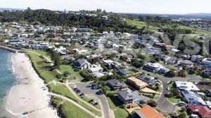 Part of Lennox Head's residential area next to Seven Mile Beach from above. You can spot the south entry to the beach and the parking area, Allens Parade, Tresise Pl, Dress Cir Dr, and The Coast Rd going up the hill in the background.