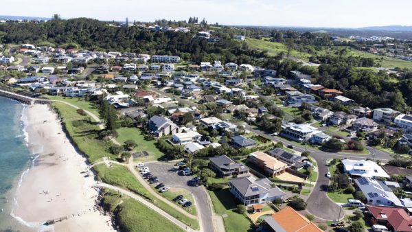 Part of Lennox Head's residential area next to Seven Mile Beach from above. You can spot the south entry to the beach and the parking area, Allens Parade, Tresise Pl, Dress Cir Dr, and The Coast Rd going up the hill in the background.