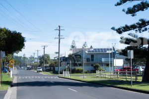 End of the Pacific Parade road in Lennox Head facing South. There are several cars parked on the street and lovely homes that are surrounded by greenery.