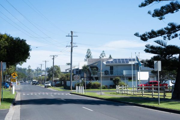 End of the Pacific Parade road in Lennox Head facing South. There are several cars parked on the street and lovely homes that are surrounded by greenery. 