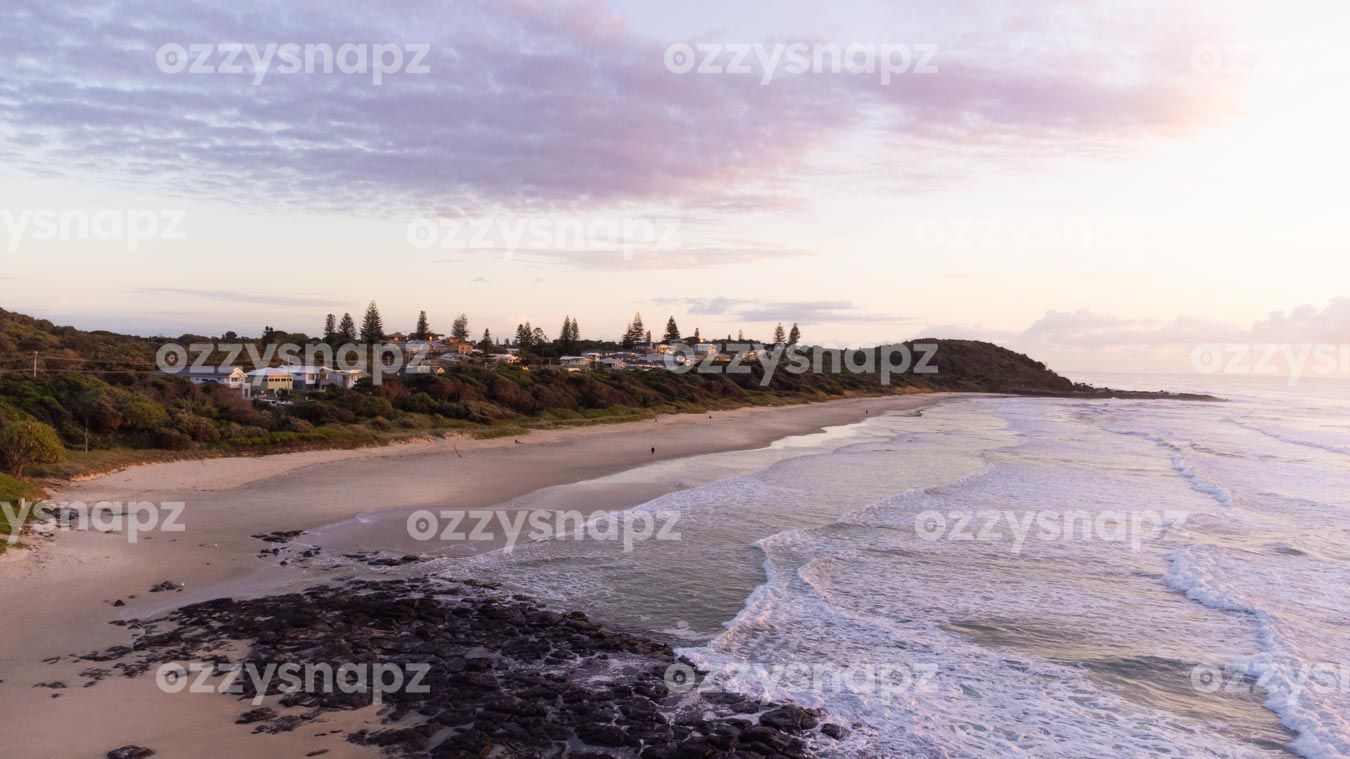 ozzysnapz_221297_low Stunning stock image of Sunrise at Shelly Beach in East Ballina. This drone shot showcases the sparkling sea, rocks, and some of the beautiful waterfront houses.