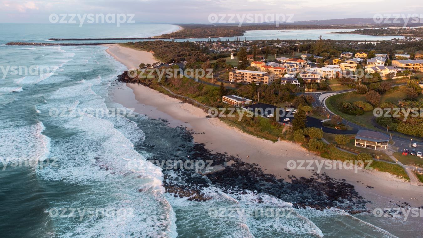 ozzysnapz_221310_low Stunning drone shot of Shelly Beach Sunrise, showcasing the beachfront houses and apartments, the Richmond River, and the Ballina Lighthouse.