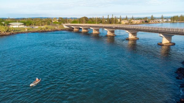 This aerial view captures the serenity and tranquillity of the morning, with a lone kayaker paddling along the river.