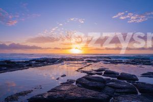 Stunning rock pool sunrise at Shelly Beach in East Ballina. This high-quality, downloadable stock image captures the colourful sky and serene reflection.