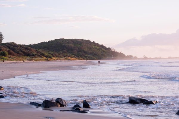 Stunning stock photo of a person walking on Shelly Beach during sunrise.