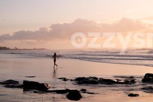 Download this stunning high-contrast lifestyle stock image of a woman running out of the water at Shelly Beach during sunrise.