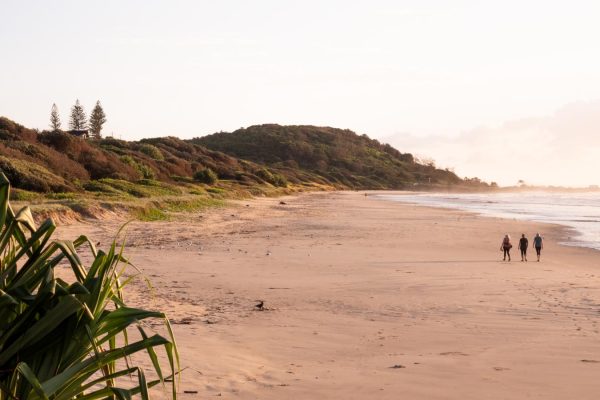 Stunning stock image of three ladies walking along the shoreline of Shelly Beach during sunrise.