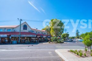 Downloadable stock image of Jonson St and Marvel St intersection in Byron Bay CBD, featuring a variety of shops and lush greenery.