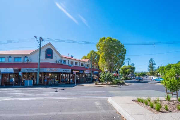Downloadable stock image of Jonson St and Marvel St intersection in Byron Bay CBD, featuring a variety of shops and lush greenery.