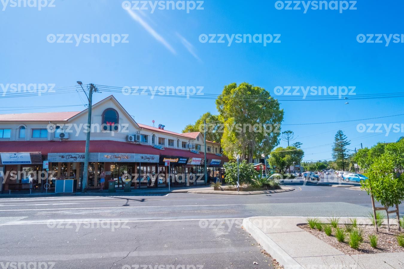 ozzysnapz_221383_low Downloadable stock image of Jonson St and Marvel St intersection in Byron Bay CBD, featuring a variety of shops and lush greenery.