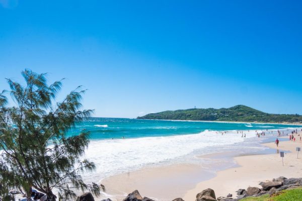 Stunning stock photo of the Main Beach in Byron Bay, with the iconic Cape Byron Lighthouse in the background.